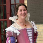 a dark-haired woman dressed in a high collared partlet and striped Venetian gown.